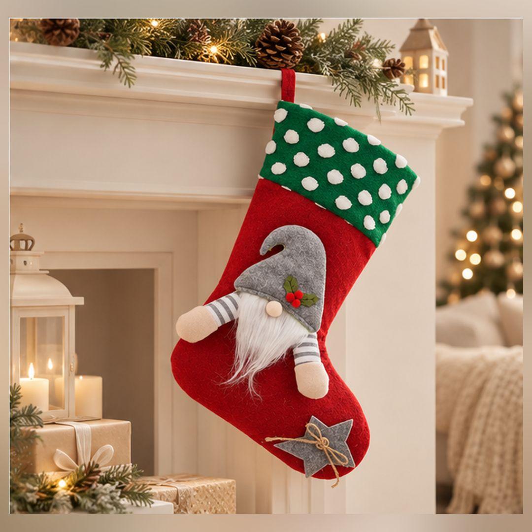 Red Christmas hanging stocking featuring green and white polka dot cuff, plush grey-hatted gnome, flowing white beard and decorative star.