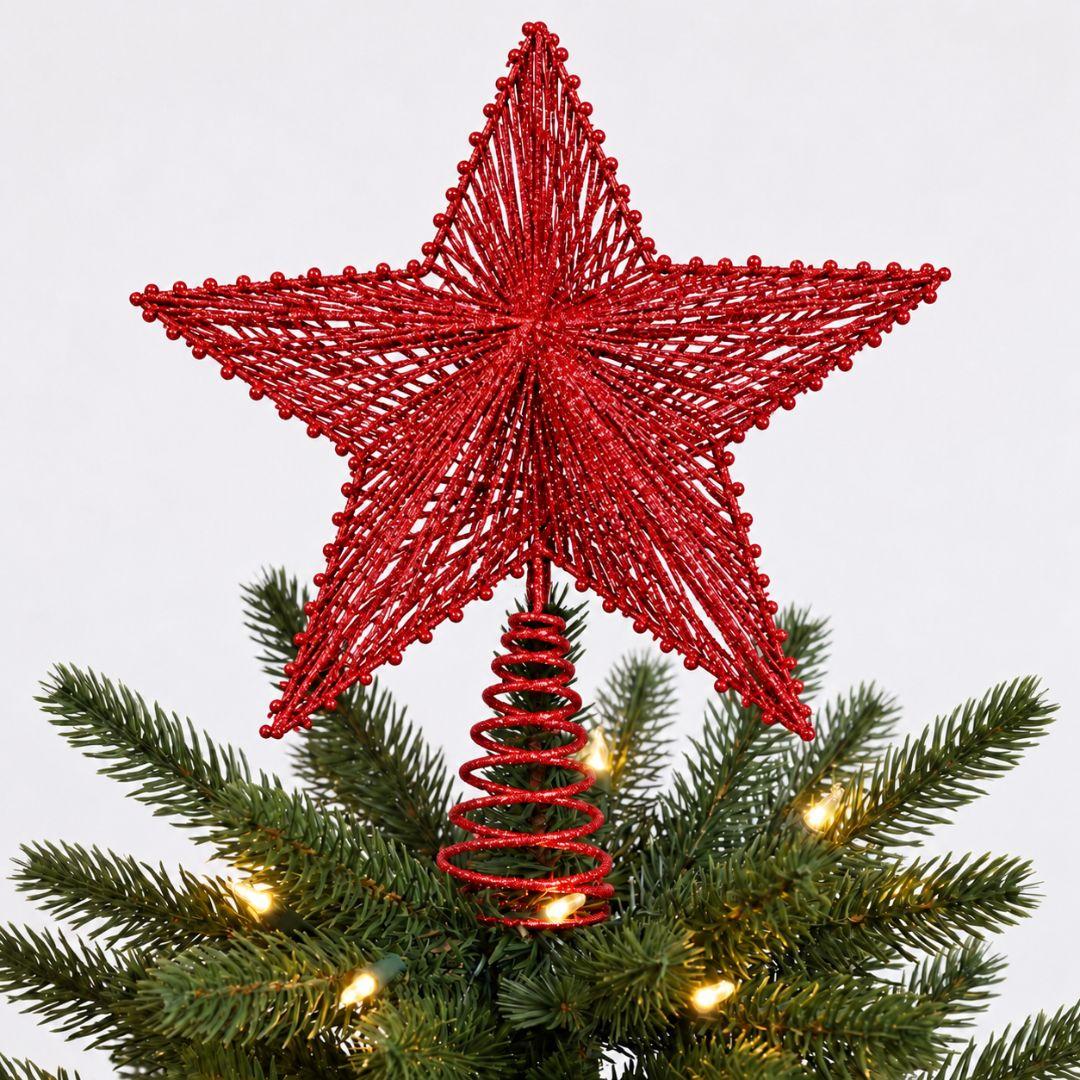 Red glitter star tree topper on a green artificial Christmas tree decorated with warm white lights