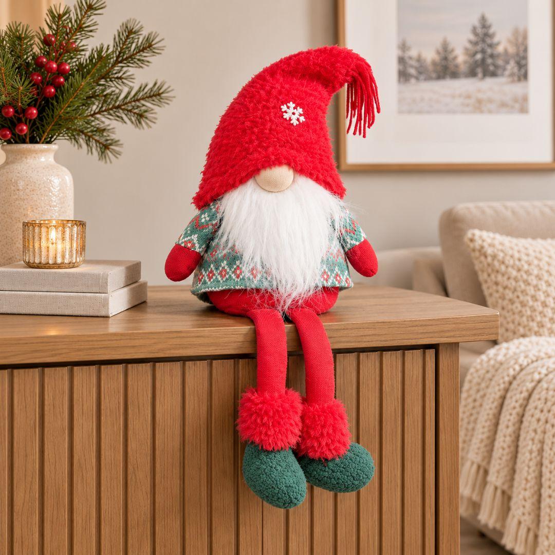 Finn Snowflake Sitting Christmas Gnome with fluffy red hat, white beard, Nordic green outfit and dangling legs on a cream beige background