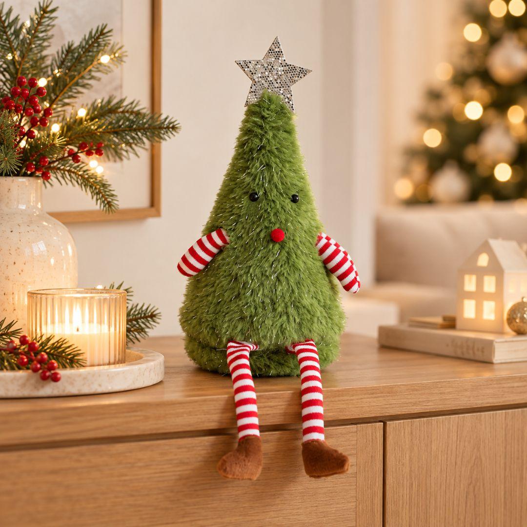 Jolly Christmas Plush Decor Design C featuring a fluffy green Christmas tree with silver star topper, red nose and dangling striped legs on a living room sideboard.