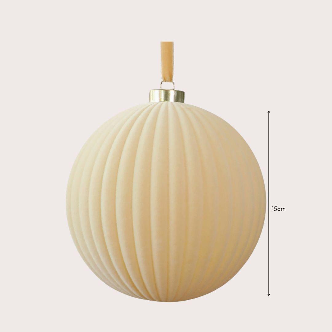 Large 15cm red and ivory velvet Christmas baubles hanging on a warm-lit artificial Christmas tree, featuring smooth and ribbed textures.