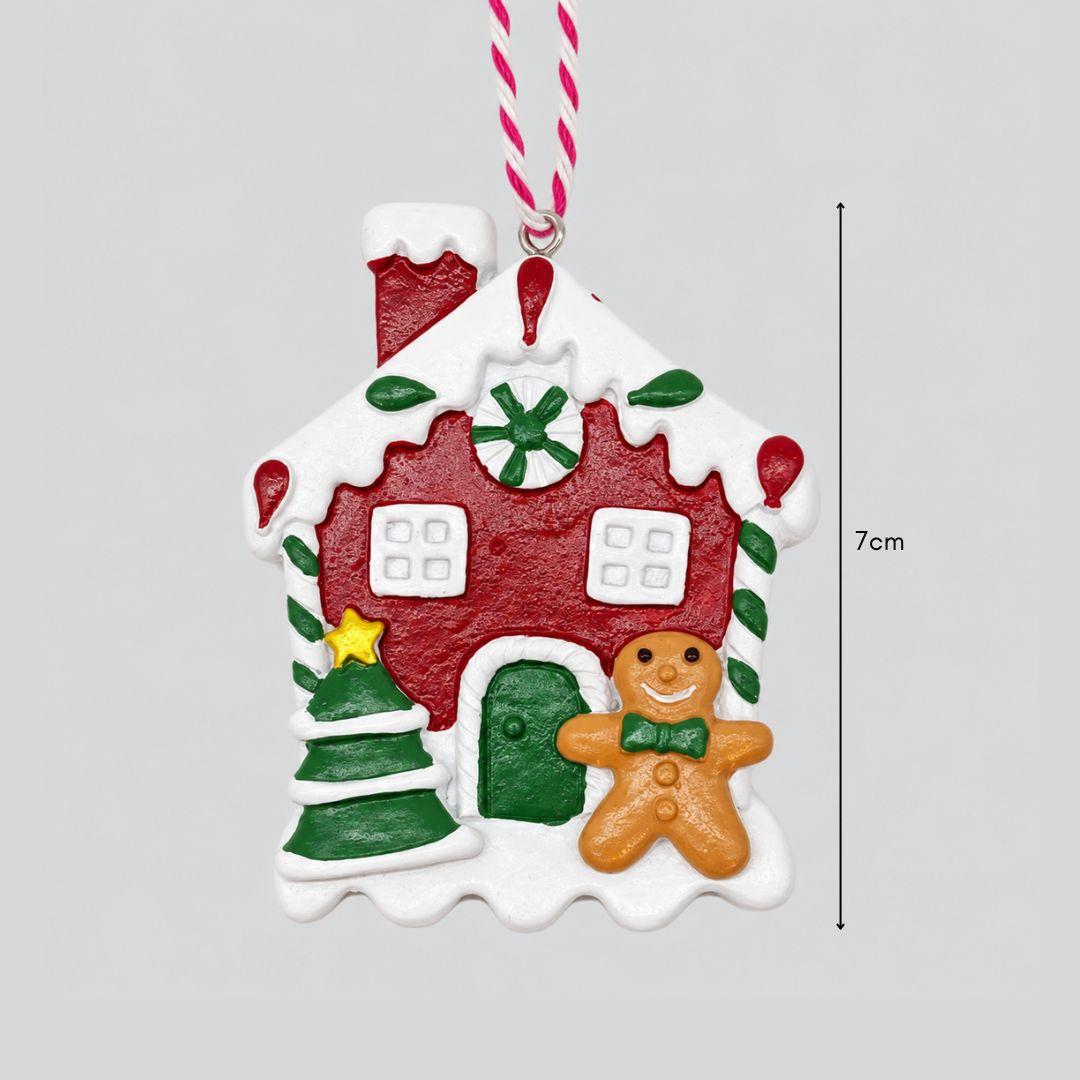 Little Joy red and green gingerbread house resin Christmas ornaments featuring snowy rooftops, candy cane details and miniature gingerbread characters on a Christmas tree.