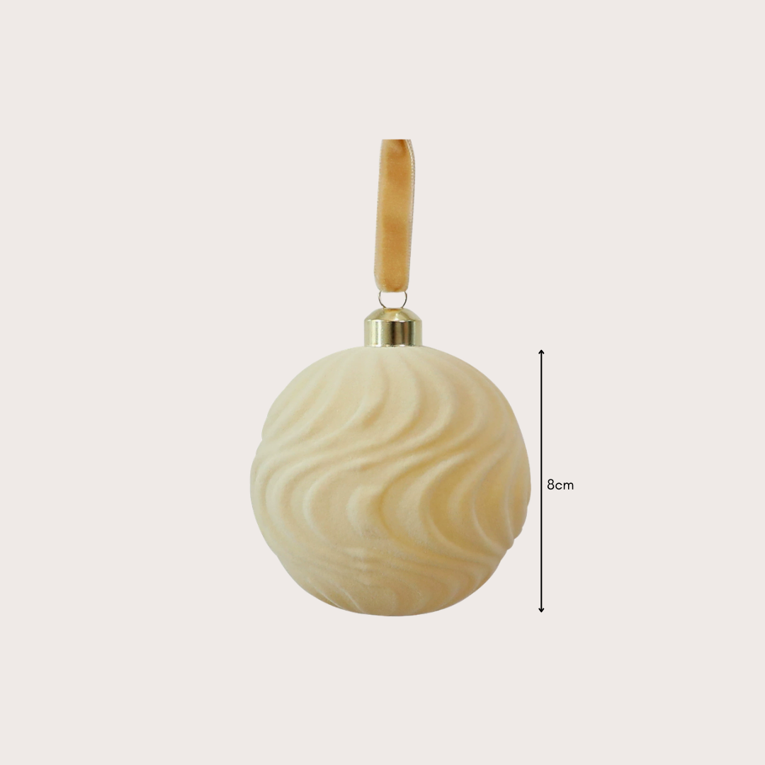Ralph Heritage 8cm red and ivory velvet Christmas baubles with sculpted geometric patterns hanging on a warm-lit Christmas tree.