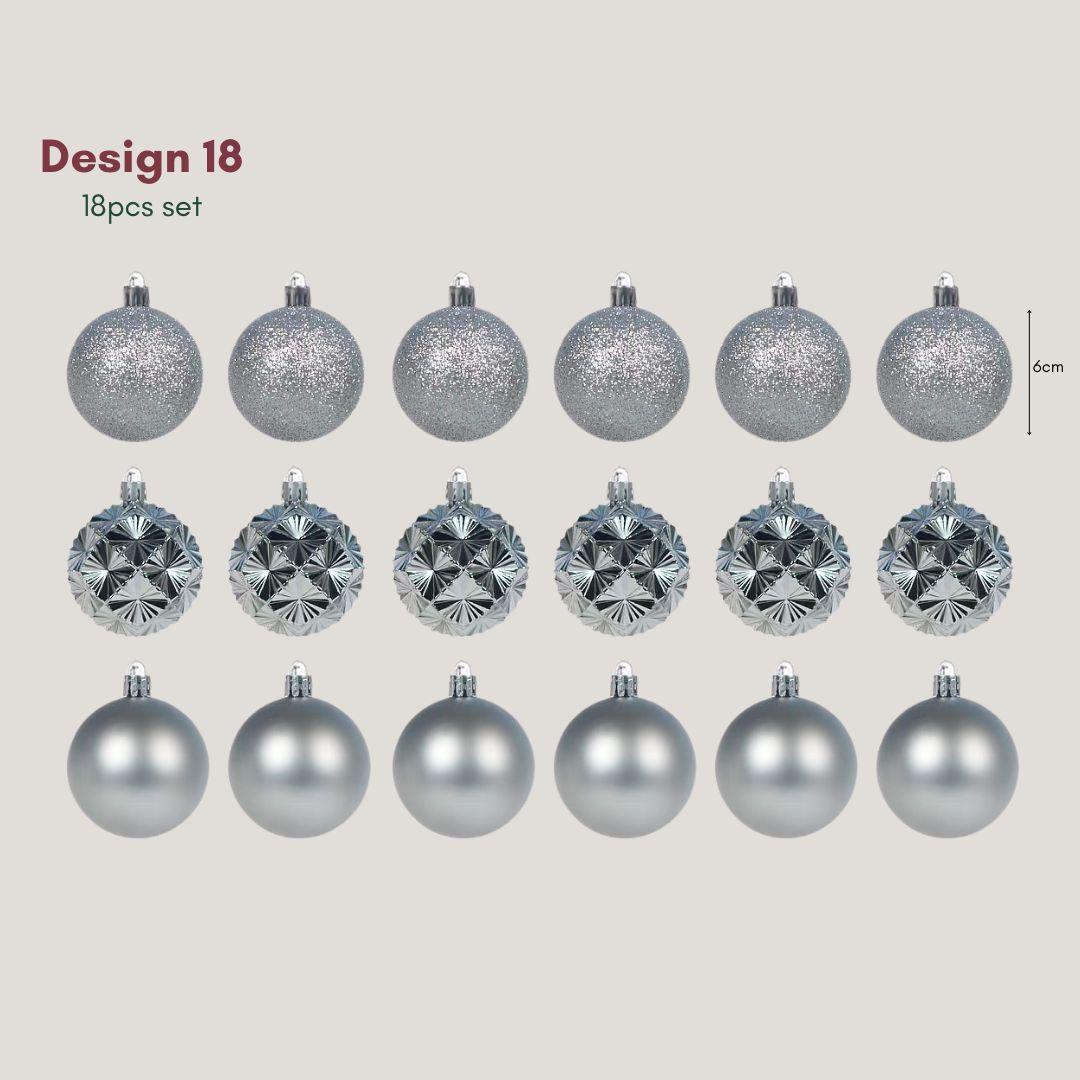 Yuletide Sparkle silver 6cm Christmas baubles featuring glitter, satin and geometric starburst finishes decorating a pre-lit artificial Christmas tree.