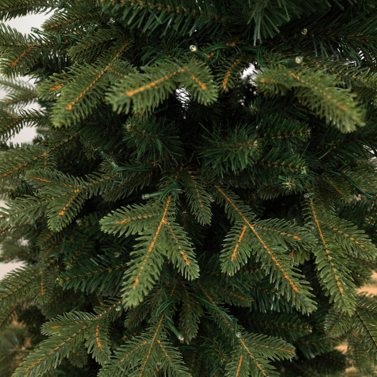 Detailed close-up of the dense dark green branches on an unlit, space saving slim tree, a realistic model for Christmas Tree Singapore.
