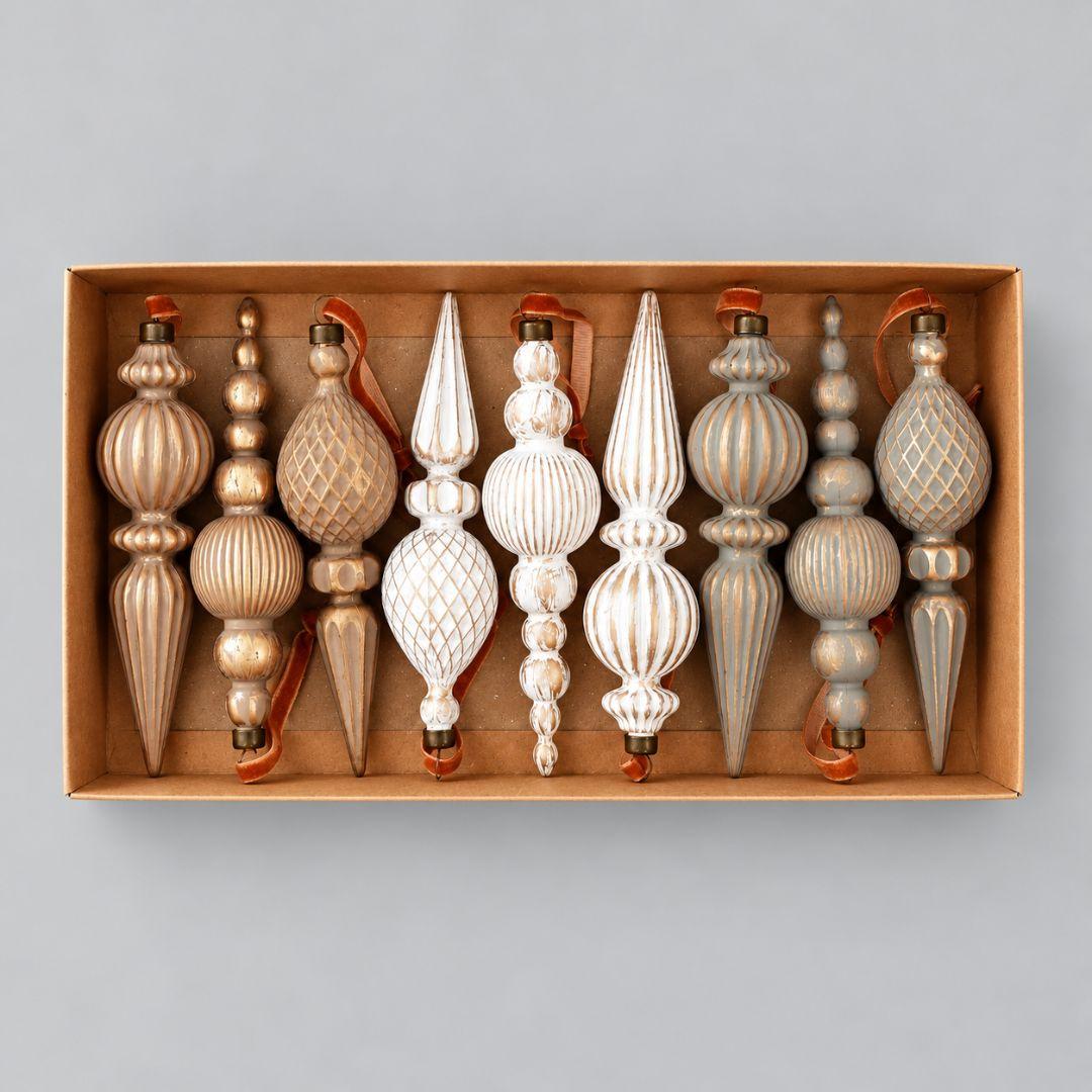 Set of 9 Aurelia vintage 16cm Christmas finial ornaments in ivory, champagne gold and sage with antique gold detailing hanging on a pre-lit Christmas tree.