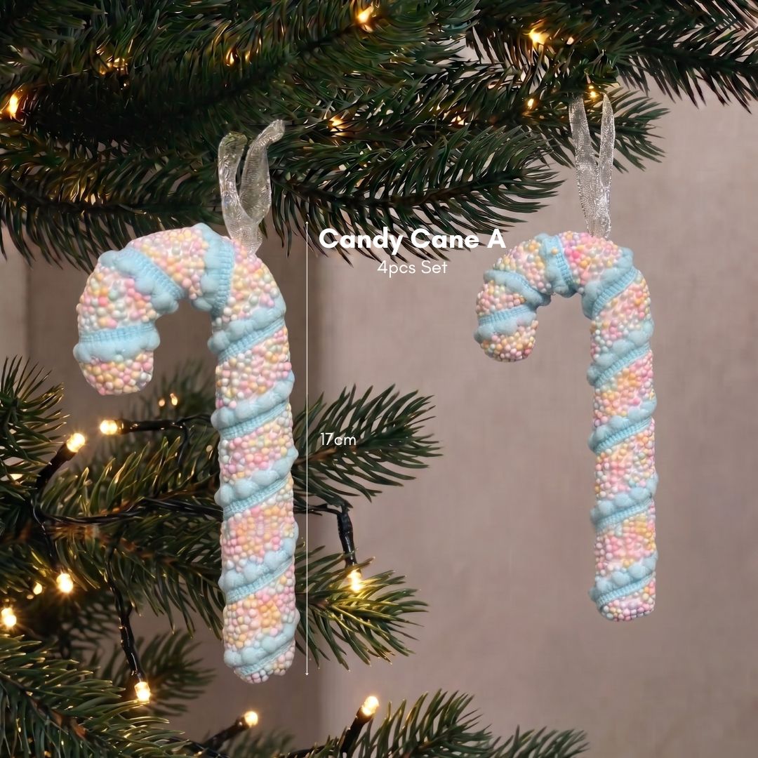 Close-up of a sweet pastel candy cane Christmas tree ornament hanging delicately on dark green pine branches.