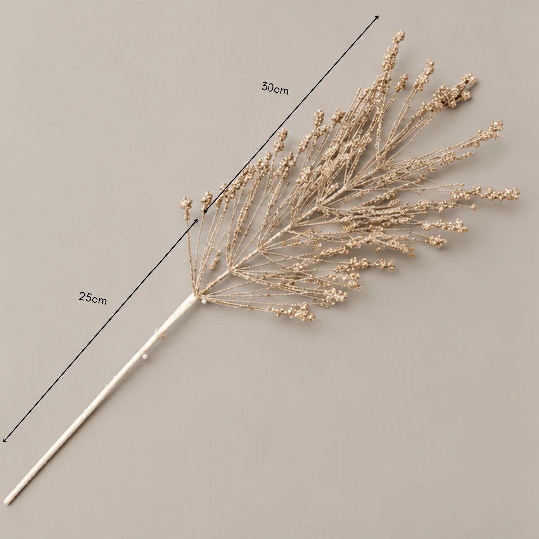 Champagne gold glitter branch Christmas tree pick featuring delicate fan-shaped branches and soft metallic accents displayed on a warm-lit Christmas tree.
