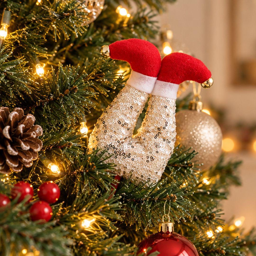 Champagne sequin Christmas elf legs tree pick with red shoes and gold bells tucked into a decorated artificial Christmas tree.