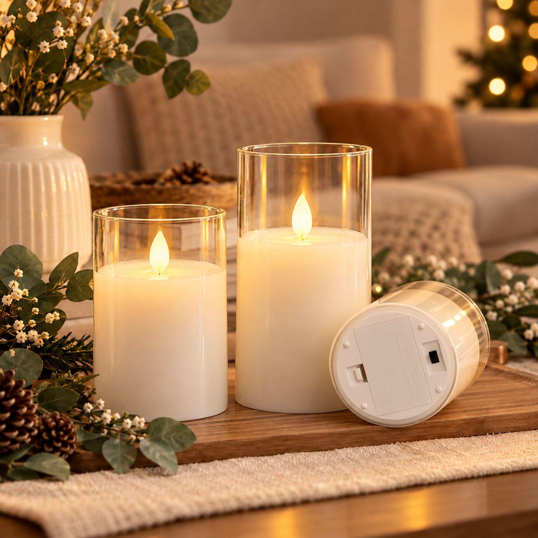 Three flameless LED glass candles in different sizes with warm flickering lights, styled on a wooden tray in a cosy minimalist living room.