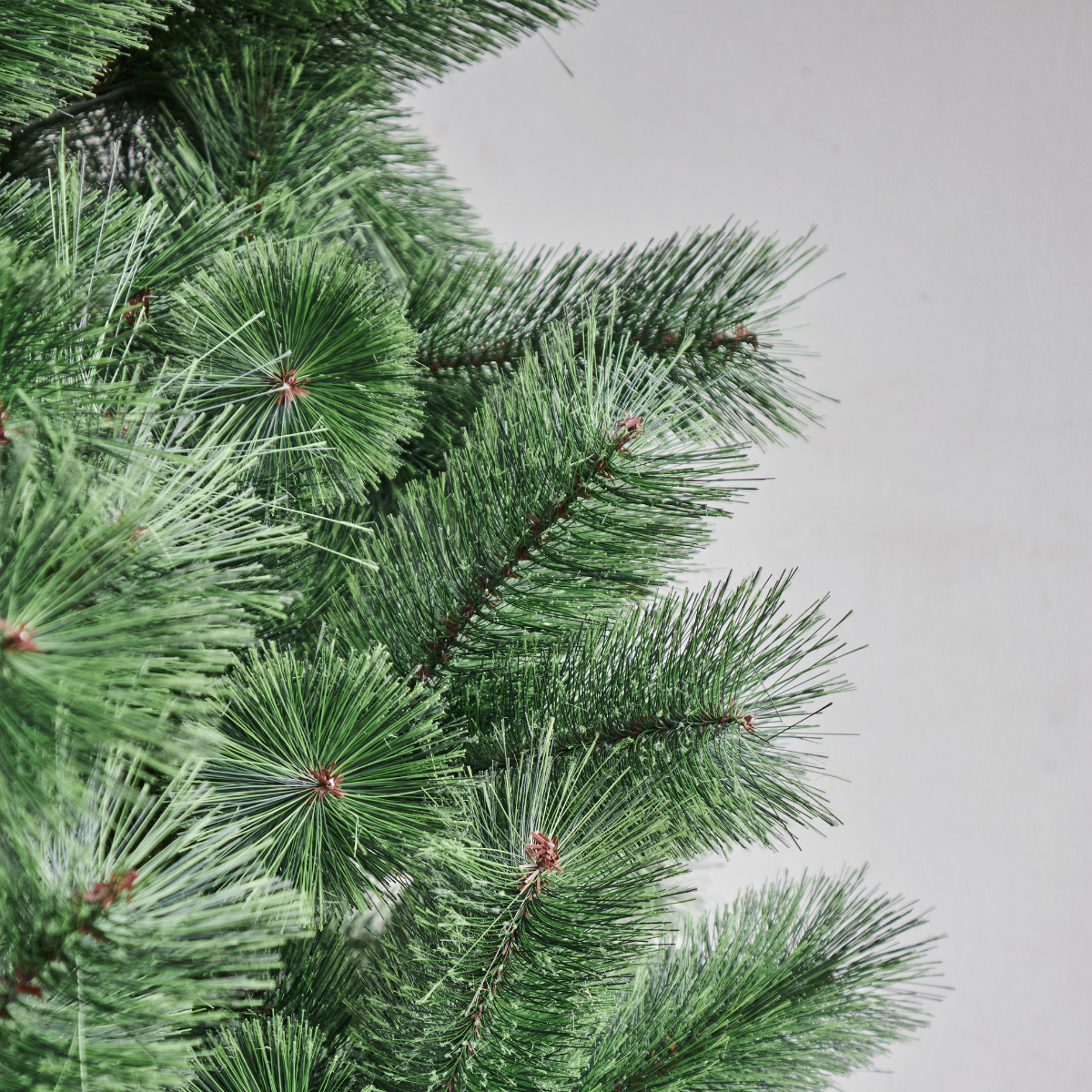 Detailed close-up of the Ferenalo Pine Christmas Tree's lush, densely packed green needle tips, showcasing lifelike foliage that rivals the quality of Tidings and Pine Concept