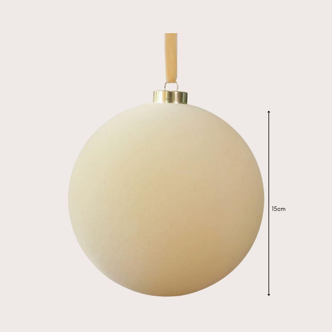 Large 15cm red and ivory velvet Christmas baubles hanging on a warm-lit artificial Christmas tree, featuring smooth and ribbed textures.