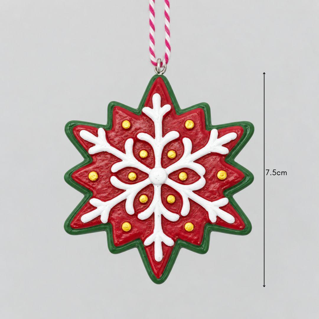 Little Joy red and green resin snowflake Christmas ornaments featuring raised white icing-inspired patterns on an artificial Christmas tree.