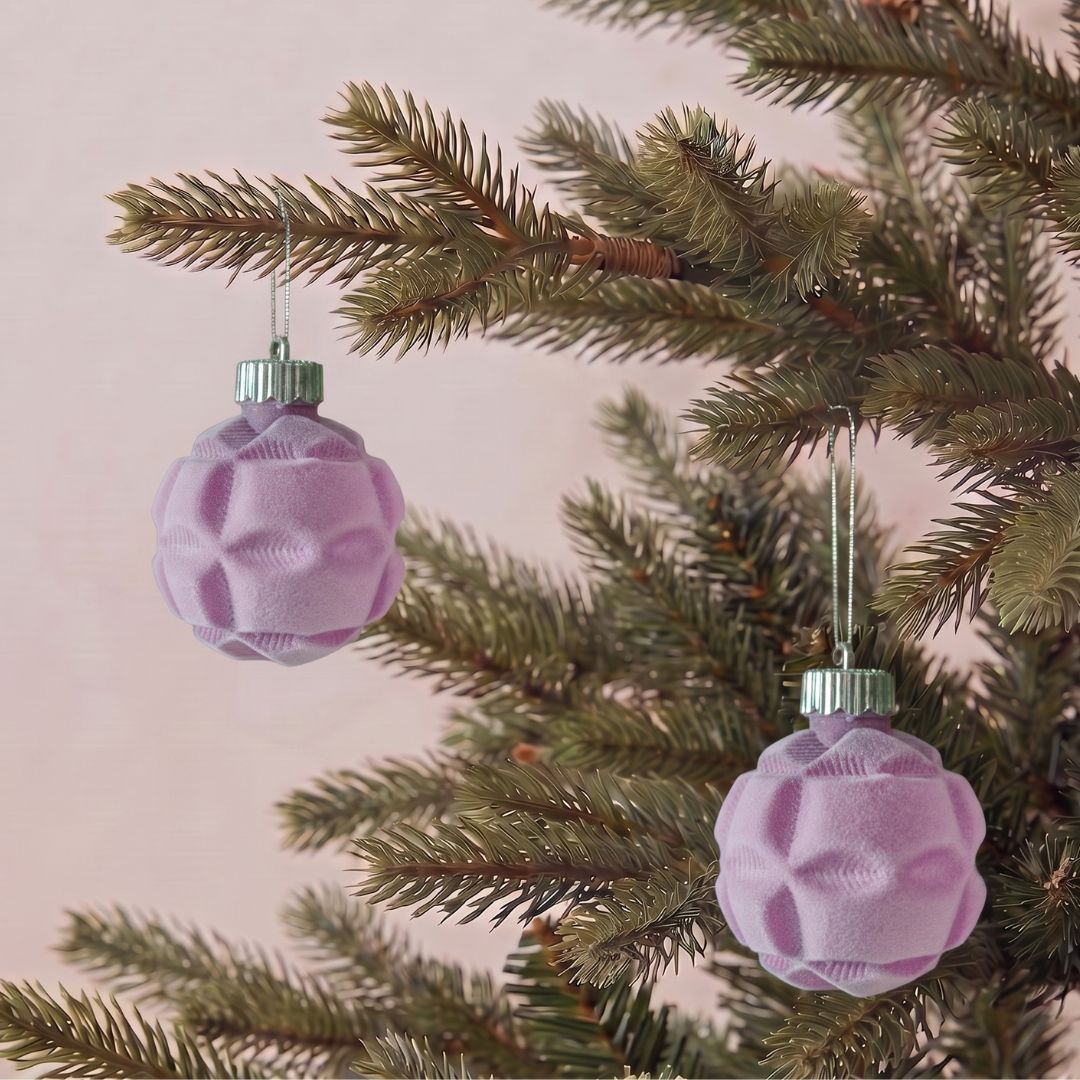 Beautifully decorated artificial Christmas tree featuring purple velvet hanging ornaments and premium festive decorations by Speckled Space