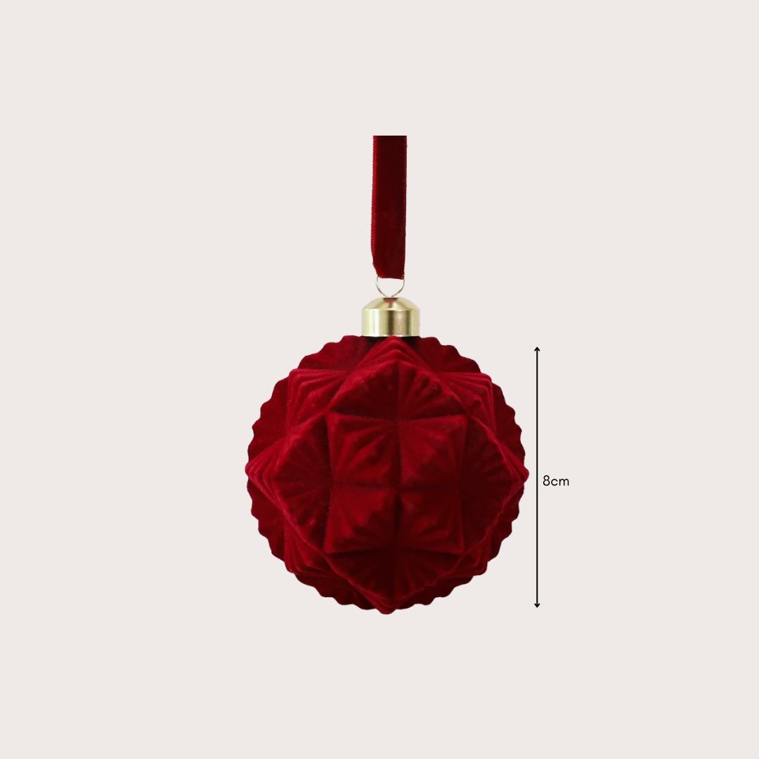 Ralph Heritage 8cm red and ivory velvet Christmas baubles with sculpted geometric patterns hanging on a warm-lit Christmas tree.