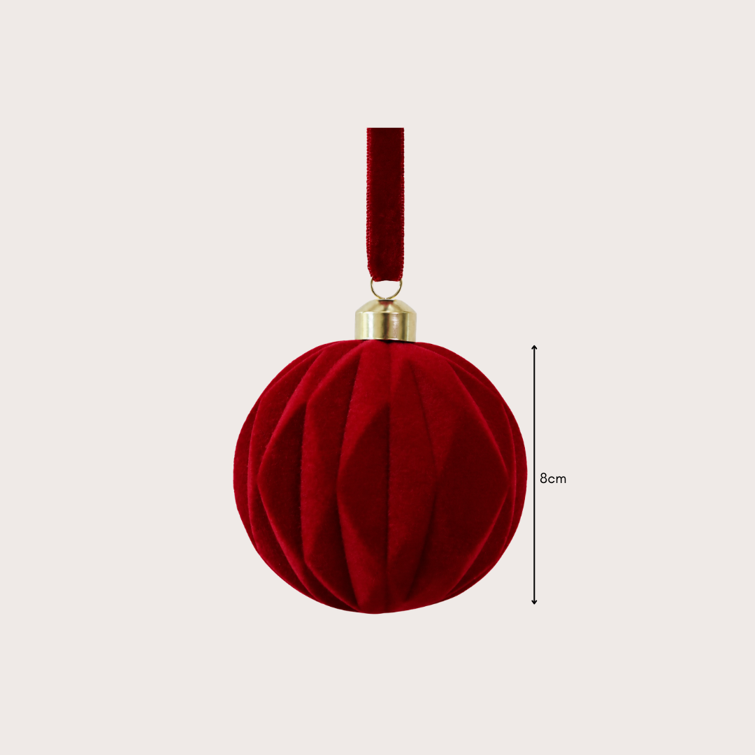 Ralph Heritage 8cm red and ivory velvet Christmas baubles with sculpted geometric patterns hanging on a warm-lit Christmas tree.