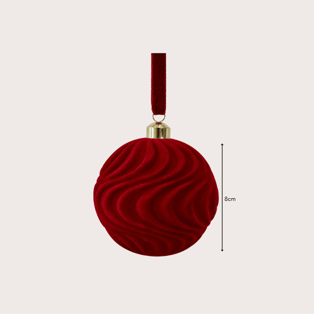 Ralph Heritage 8cm red and ivory velvet Christmas baubles with sculpted geometric patterns hanging on a warm-lit Christmas tree.