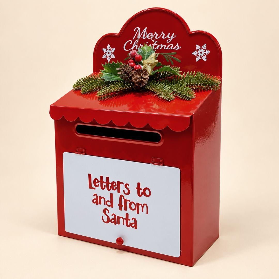 Santa's Merry Mail Christmas Letterbox made of red metal with white Letters to and from Santa panel and festive greenery on beige background