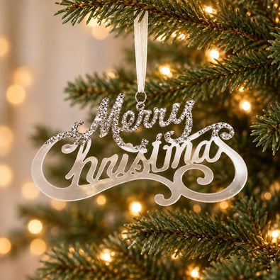 Silver acrylic Merry Christmas hanging ornament with decorative script lettering and sparkling accents displayed on an artificial Christmas tree.