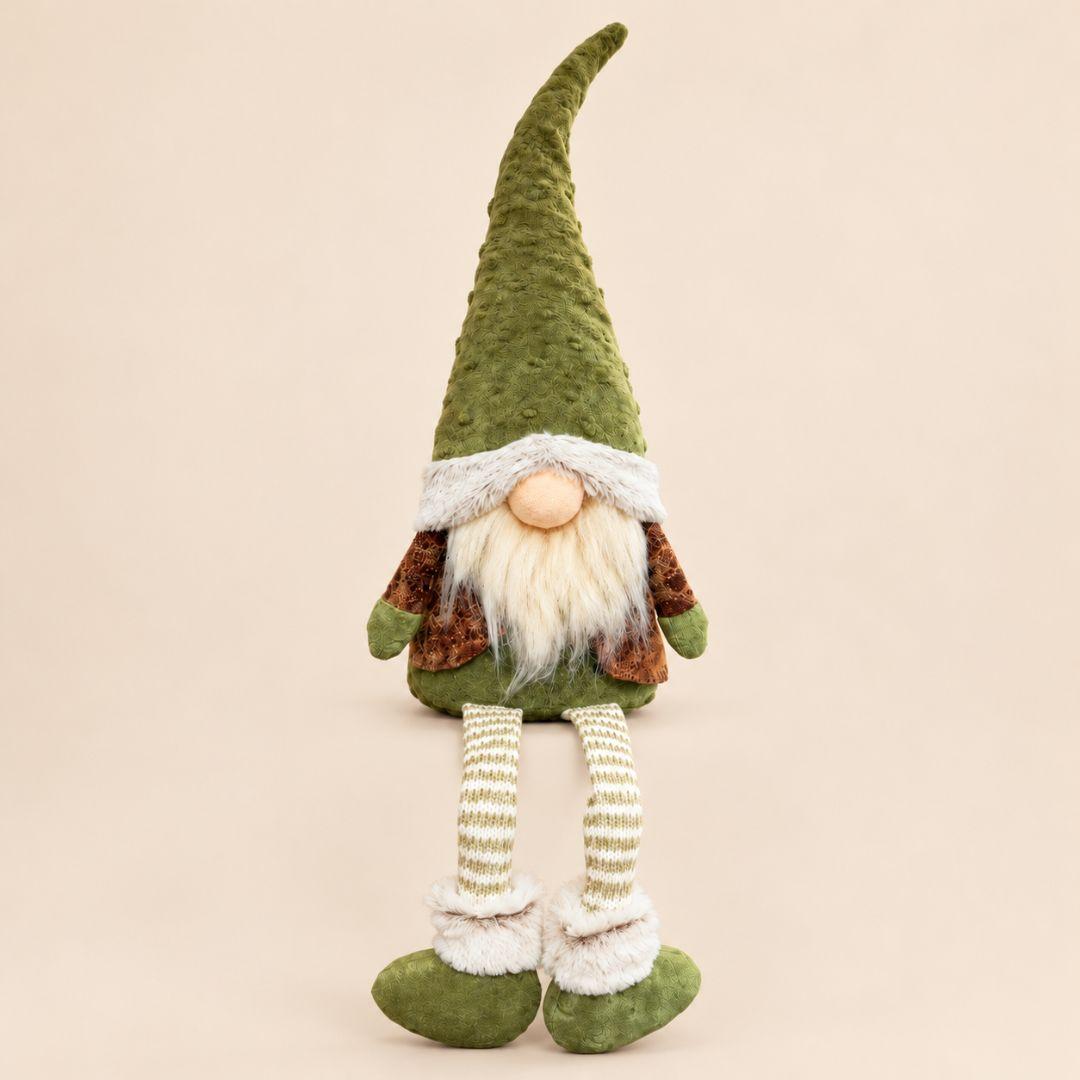 Willow Woodland green sitting Christmas gnome with dangling knitted legs displayed on a wooden console in a cosy living room