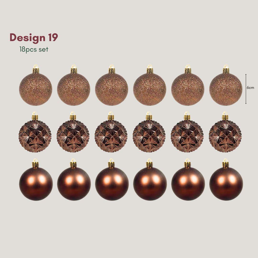 Yuletide Sparkle bronze 6cm Christmas baubles with copper-toned glitter, satin and geometric starburst finishes hanging on a pre-lit artificial Christmas tree.